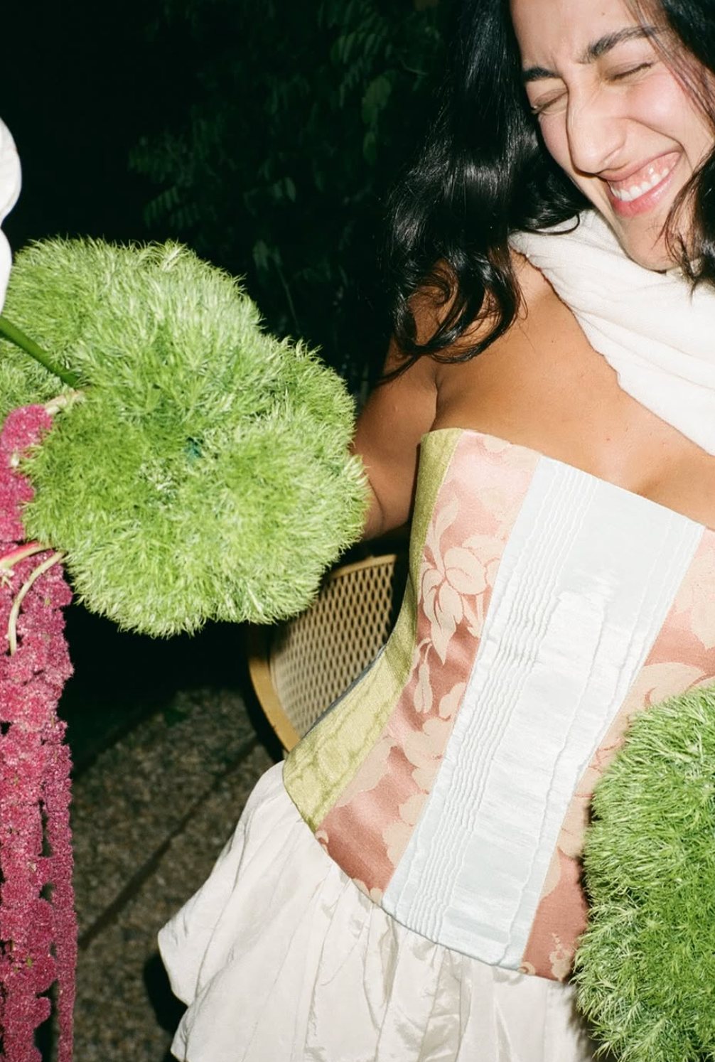 A guest laughing with armfuls of flowers
