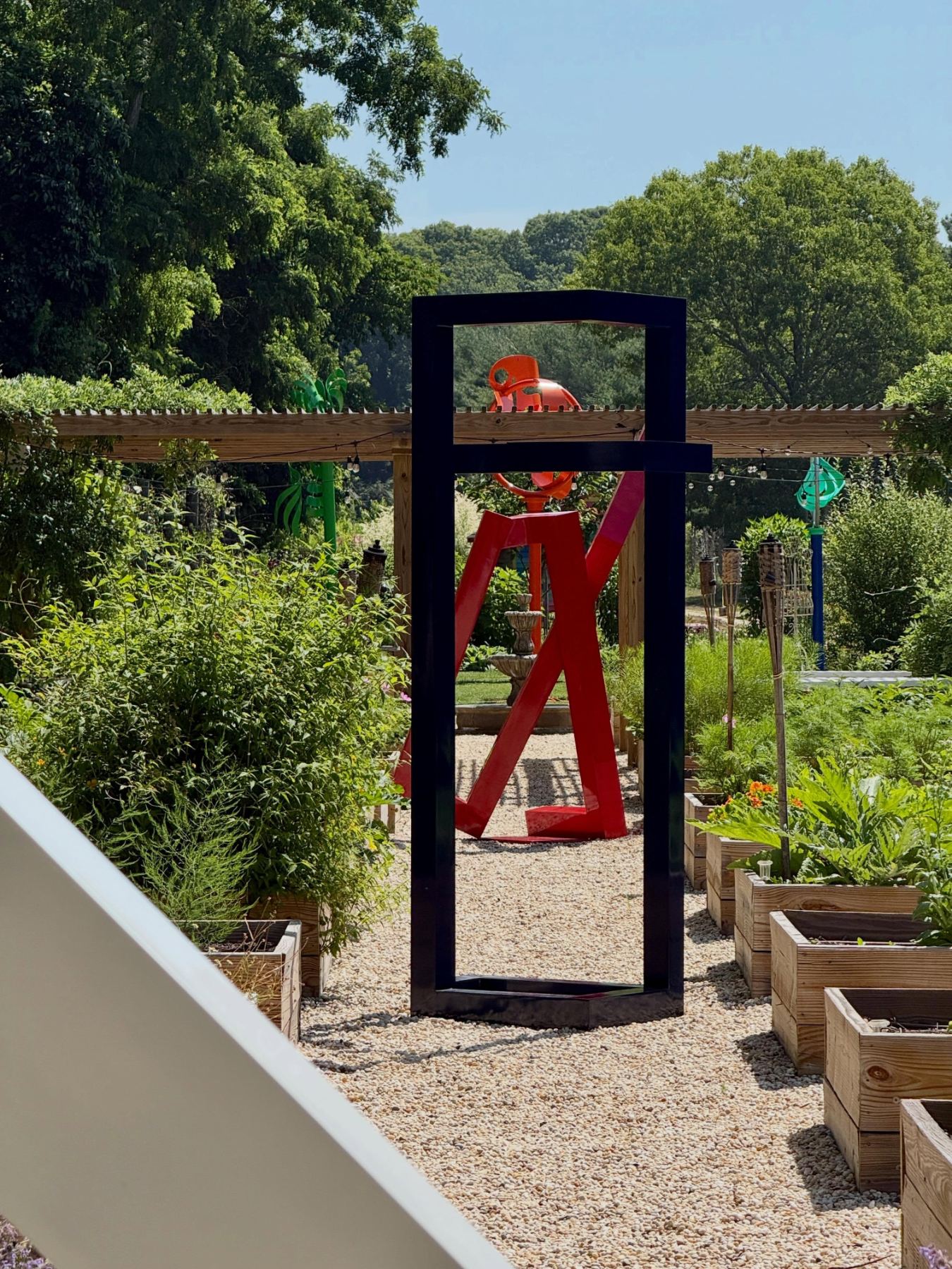 A black frame sculpture framing red steel