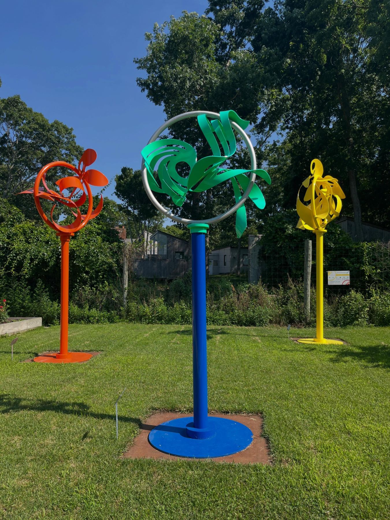 Three painted pinwheel sculptures on the lawn