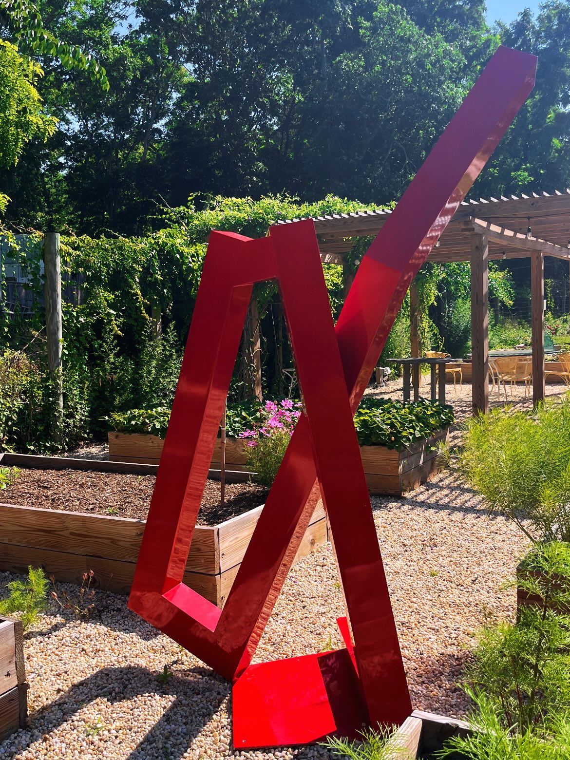 Red steel sculpture by the beds